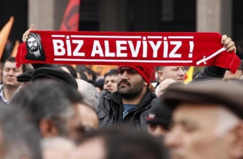 A protester holds a banner reading "we are alevi" as he and many others wait to hear the decision of the court in front of a courthouse in Ankara March 13, 2012. REUTERS/Umit Bektas